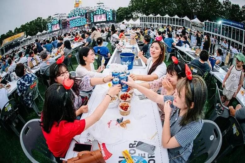 Visitors to the Daegu Chimac Festival enjoying beer and fried chicken at a park in the South Korean city of Daegu over five days in July. The event now attracts more than a million visitors yearly amid the chimaek craze. PHOTO: DAEGU CHIMAC FESTIVAL