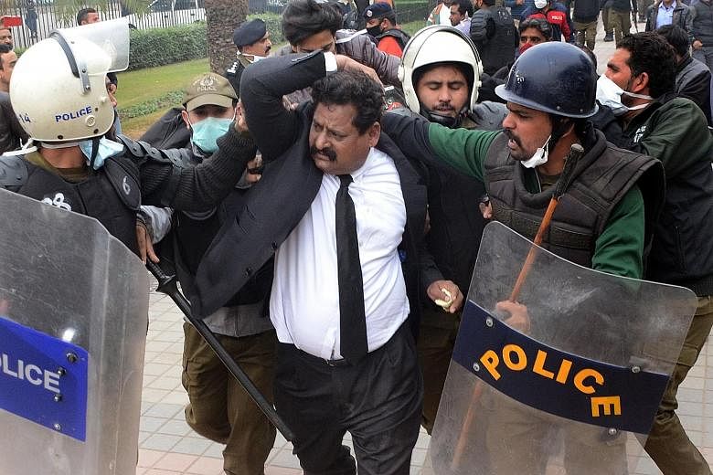 Police arresting a lawyer after he and his colleagues clashed with doctors outside the Punjab Institute of Cardiology in Lahore, Pakistan, on Wednesday. PHOTO: EPA-EFE