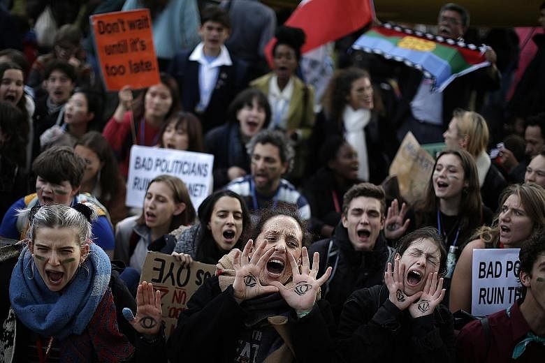 People shouting slogans during a march organised by the Fridays for Future movement of school students outside the COP25 climate talks congress in Madrid on Friday.
