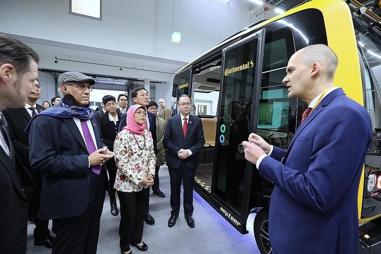 President Halimah also visited automotive manufacturing company Continental's facility in Frankfurt, where she listened to a presentation on driverless vehicles by an employee. Also present was (from right) Dr Tan, Education Minister Ong Ye Kung, Pro