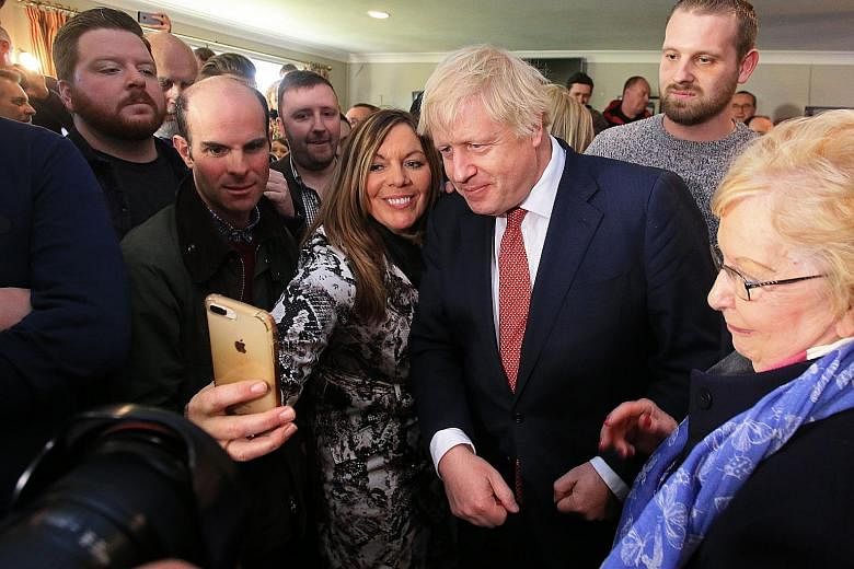 British Prime Minister Boris Johnson with supporters during a visit to Sedgefield Cricket Club in County Durham in north-east England yesterday, after his Conservative Party's election win.