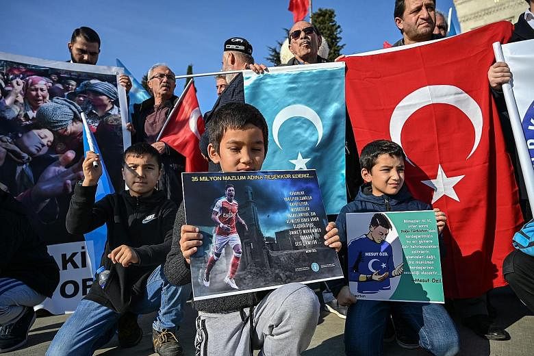 Uighur children with placards of Arsenal footballer Mesut Ozil and his Instagram and Twitter posts during a demonstration at Beyazid Square in Istanbul on Saturday. The posts accused Muslims of staying silent over the mistreatment of the Uighur Musli