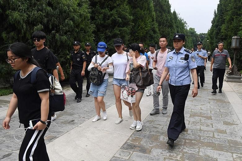A group of Chinese petitioners being escorted out of a park in Beijing by police and security personnel in August last year before being taken away in buses, as the authorities quashed a planned protest against peer-to-peer lending platform losses. P