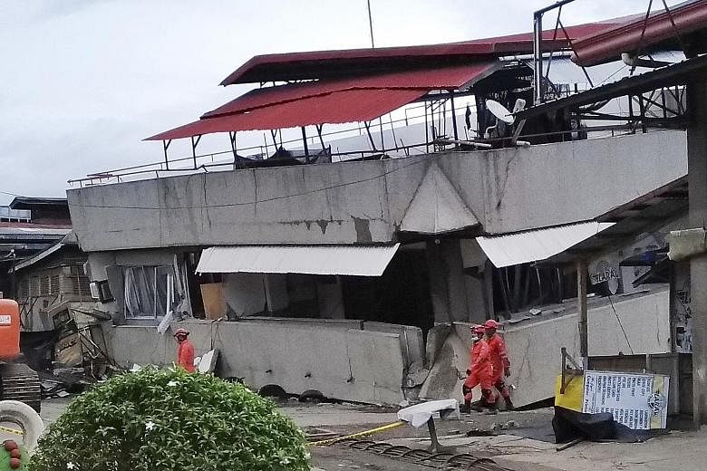 Rescuers at the South Green Marketing building in Davao del Sur province which collapsed in Sunday's magnitude-6.8 quake. Two bodies were pulled out from the building yesterday, while a third one could not be immediately retrieved, as rescuers scramb