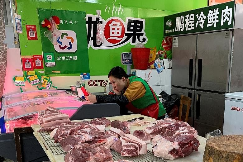 A pork vendor waiting for customers at a market in Beijing last month. Pork prices more than doubled this year after the industry was hit by African swine fever, said China's National Bureau of Statistics yesterday. PHOTO: REUTERS