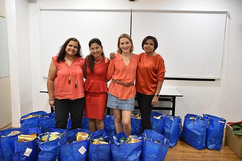 Helping and Empowering Our Neighbours' founder Nilofar Iyer (at far right) with volunteers (from far left) Surabhi Singh, 41, Stacey Lwin, 37, and Armelle Drouffe, 44, at an Awwa centre in Lengkok Bahru last month. They had just finished packing groc