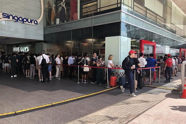 Five Guys Singapore (left) had about 100 people in line prior to the store's opening at 11am. The brand prides itself on its hand-cut fries cooked in peanut oil, as well as burger patties with an 80-20 lean meat-to-fat ratio.