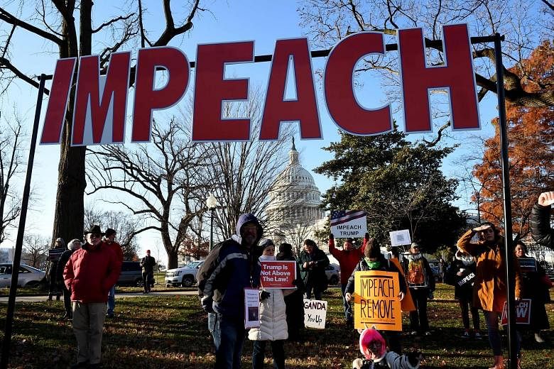 People rallying in support of the impeachment of US President Donald Trump in front of the US Capitol, as the House readies for a historic vote. Organisers said the nationwide protests were to demonstrate to lawmakers that their constituents are behi