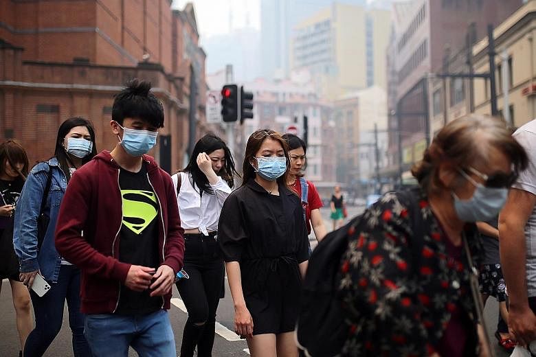 Pedestrians wearing masks last week in Sydney's central business district as smoke from bush fires in New South Wales blanketed Australia's most populous city. Doctors have labelled the haze a public health emergency, while scientists and firefighter