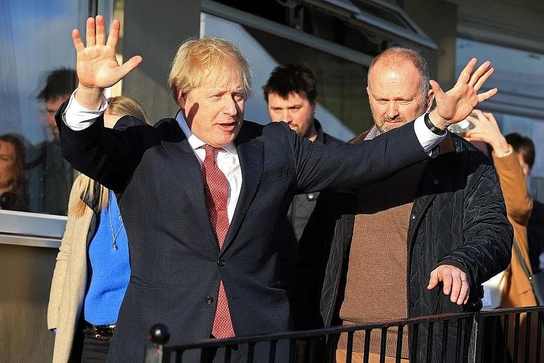 Britain's Prime Minister Boris Johnson in jubilant mood following his general election victory. Mr Johnson's political strategies are similar to those of US President Donald Trump, says the writer, adding that Democrats should focus on winning the ne