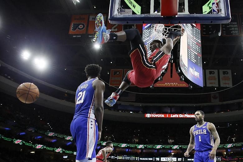Miami Heat's Bam Adebayo, with 23 points in the game, dunking over Philadelphia 76ers forward Joel Embiid on Wednesday. PHOTO: ASSOCIATED PRESS