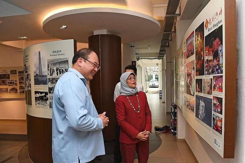 President Halimah Yacob viewing the Singapore Federation of Chinese Clan Associations' heritage gallery with SFCCA president Tan Aik Hock yesterday. During her visit, Madam Halimah highlighted the importance of attracting young people to engage in an