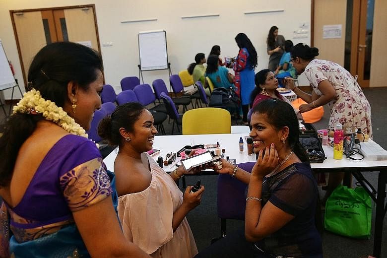 Indian migrant worker Anukrishna (at right) all smiles after having her make-up done by volunteer Aavishka Ragam during a Mother's Day event organised by Women of Shakti at the National Volunteer and Philanthropy Centre's A Good Space in May.