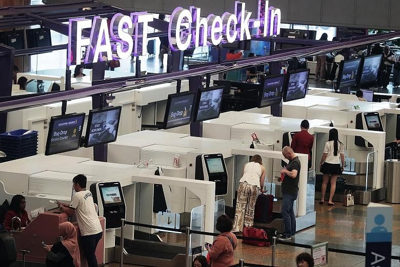 Passengers at the automated check-in area at Changi's Terminal 2 departure hall on Dec 2. More staff will be added to help travellers using the automated check-in kiosks and automated bag-drop machines, said Changi Airport Group.