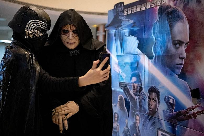 Moviegoers in Beijing dressed as Star Wars characters taking a wefie, as the latest instalment in the Skywalker saga opened worldwide this month. The writer says the success of the series has obviated a lot of its original virtues, and that much of t