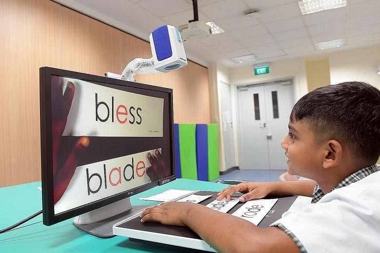 Tejas Mahendran, seven, who has low vision due to cone-rod dystrophy, uses a portable video magnification system that enlarges words on the class whiteboard and materials like worksheets to help him read.
