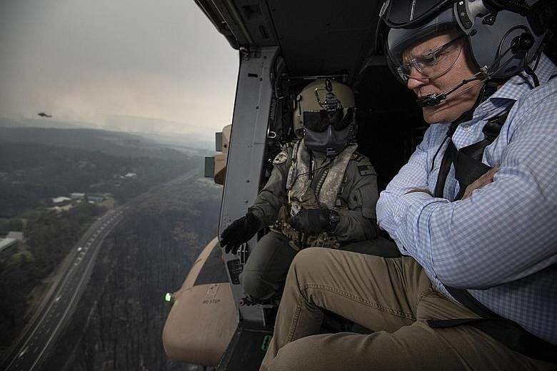 Australian Prime Minister Scott Morrison surveying areas affected by bush fires in the Blue Mountains, west of Sydney, yesterday. He has fiercely defended the lucrative coal industry in Australia, the world's largest exporter of coal and liquefied na