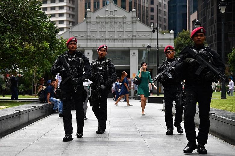 Officers from the Police Tactical Unit of the Special Operations Command on patrol in Raffles Place yesterday. They are among the specialist police units on patrol in the city area as Singapore prepares to ring in the new year.