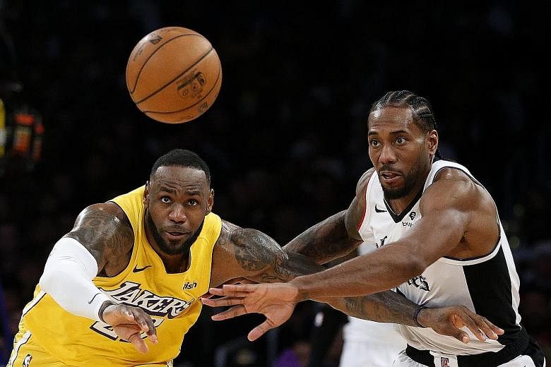 The Los Angeles Lakers' LeBron James vying for a loose ball with the Clippers' Kawhi Leonard during the second half of their NBA game on Wednesday. The Clippers forward's game-high 35 points, including 11 in the final quarter, helped his team overtur