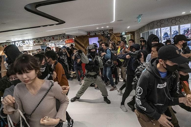 Protesters clashing with police at a shopping mall in the Sha Tin area of Hong Kong on Christmas Day. Rallies and clashes have reignited over the Christmas period, and more protests are scheduled at the New Town Plaza in Sha Tin today and in Sheung S