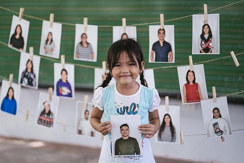 Children in Santa Maria, 80km south of Manila, select their sponsors from various photographs. The children say they are drawn to friendly smiles or even the clothes the sponsors are wearing. PHOTO: CRISTINA MENINA FOR THE STRAITS TIMES