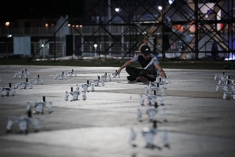 Star Island team members preparing the drones before a scheduled rehearsal at The Float @ Marina Bay last night. The aerial performance is backed by a 30-strong drone team, which includes 10 specialist pilots and engineers.