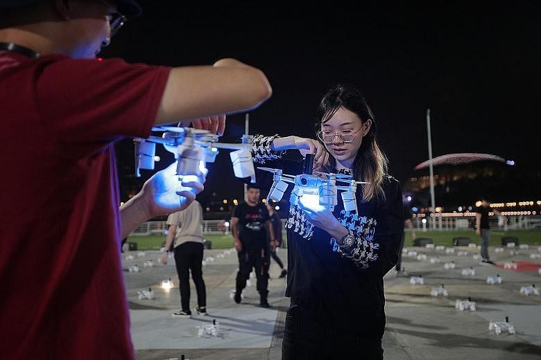 Star Island team members preparing the drones before a scheduled rehearsal at The Float @ Marina Bay last night. The aerial performance is backed by a 30-strong drone team, which includes 10 specialist pilots and engineers. 
