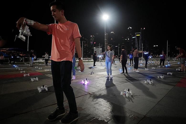 Star Island team members preparing the drones before a scheduled rehearsal at The Float @ Marina Bay last night. The aerial performance is backed by a 30-strong drone team, which includes 10 specialist pilots and engineers.