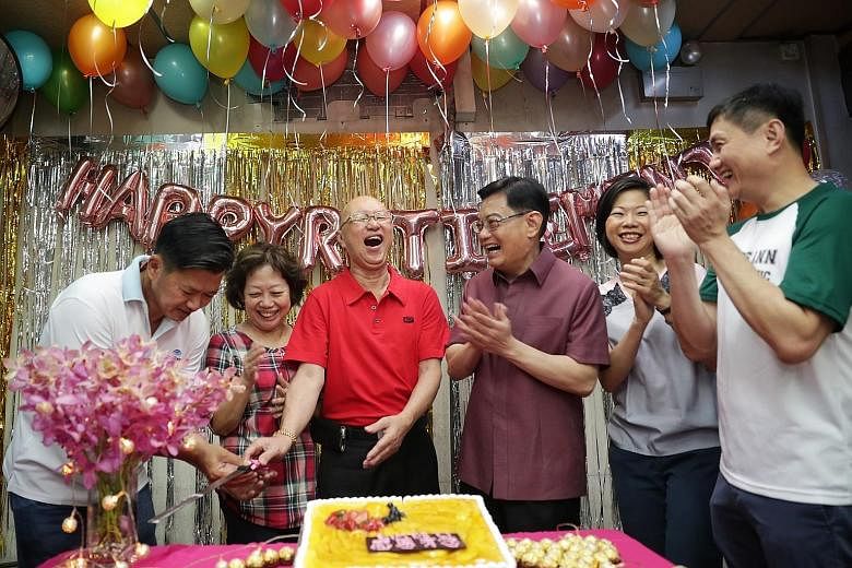 Mr Lim Kok Peng (in red) with his wife Chen Meng Keun beside him at a farewell party organised by residents yesterday. The couple are retiring after running Lim De Li minimart in Toh Yi for almost 20 years. With them at the party were (from left) grassroo