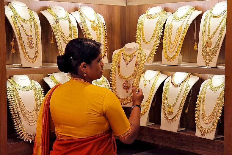A saleswoman picking gold necklaces to show to a customer at a jewellery showroom in Kochi, India, in May. Spot gold rose 0.3 per cent to US$1,514.97 an ounce as of 1.51pm in New York on Monday, extending its December gain to 3.5 per cent, according 