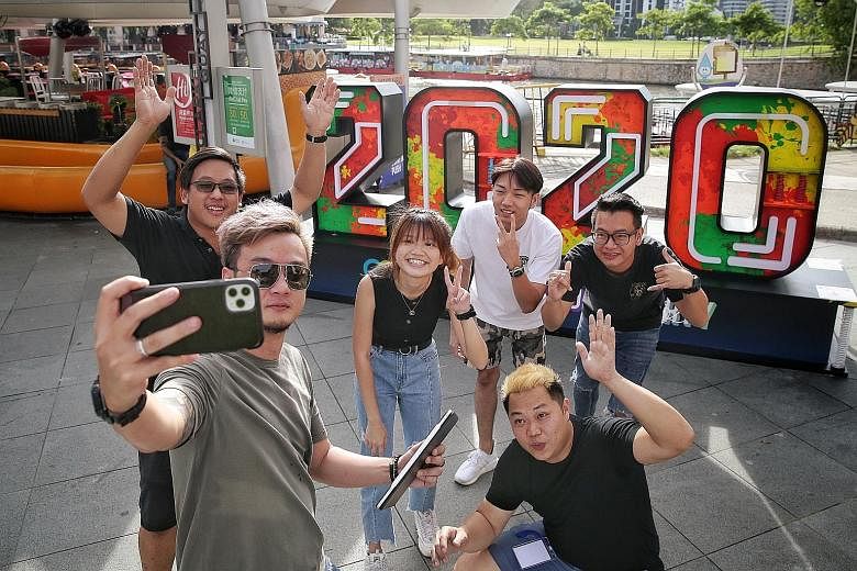 An events crew taking photos yesterday in front of their company's handiwork, a neon "2020" photo wall display at Clarke Quay, ahead of New Year's Eve celebrations last night. Prime Minister Lee Hsien Loong said in his New Year message that having be