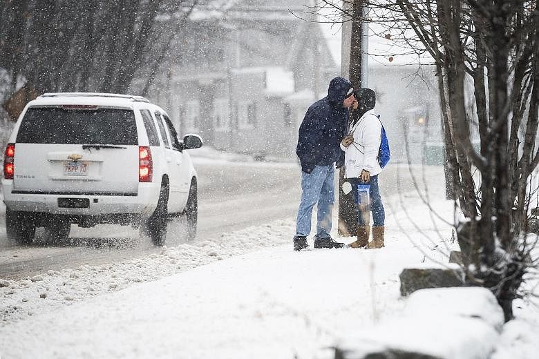 Leaning in for a quick kiss in Fitchburg, Massachusetts, during a snowstorm in the area on Monday. A severe thunderstorm warning was issued for parts of the state. PHOTO: ASSOCIATED PRESS