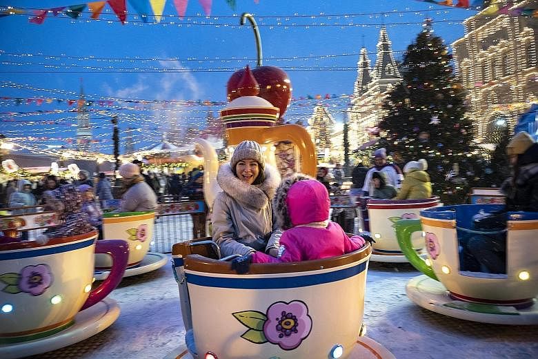 Muscovites in holiday mood at Red Square, which has been decorated for Russia's New Year and Orthodox Christmas celebrations. PHOTO: ASSOCIATED PRESS