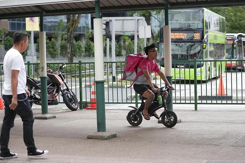 Land Transport Authority officers outside Compass One mall in Sengkang yesterday. Besides taking action against errant e-scooter users, they also checked devices such as power-assisted bicycles (above) to ensure they complied with the authorities' sa