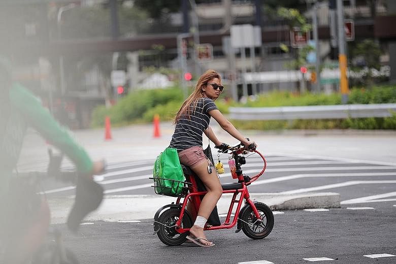 Electric scooter riders outside Causeway Point in Woodlands yesterday. When The Straits Times visited the mall in the afternoon, seven e-scooter users on footpaths were sighted within 30 minutes.