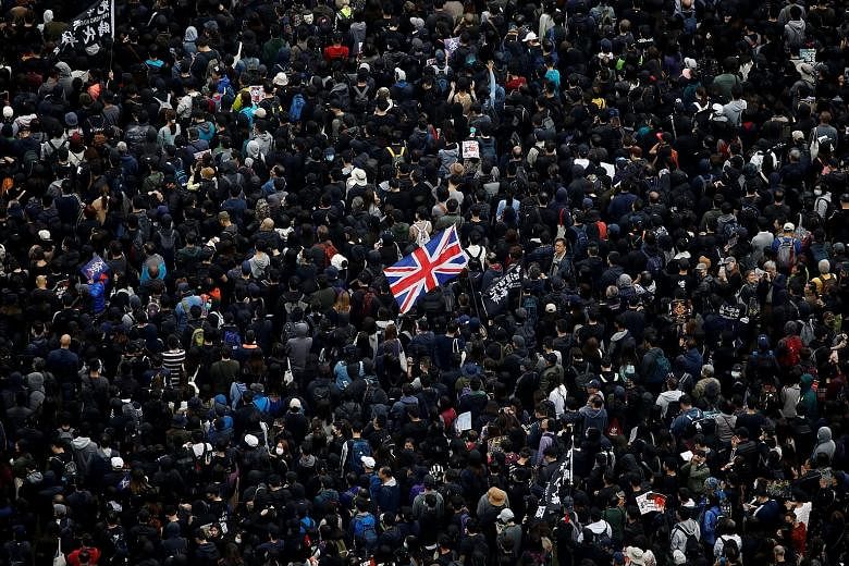 A protester holding up a British flag during an anti-government rally in Hong Kong on Wednesday. Sources said China has temporarily suspended the Shanghai-London Stock Connect scheme because of political tensions with Britain, with two of them highli