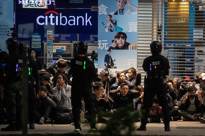 Hong Kong police detaining protesters in Causeway Bay on New Year's Day. A 12-year-old boy was among the 420 people arrested over the holiday period, and four officers were injured, police said. PHOTO: BLOOMBERG