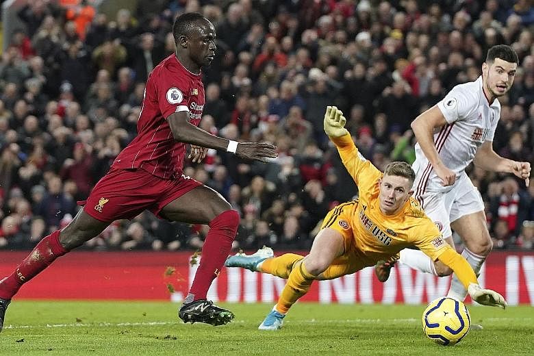 Sadio Mane scoring Liverpool's second goal during their EPL match against Sheffield United at Anfield on Thursday. Mohamed Salah was the other scorer in the 2-0 win that took Liverpool's lead over second-placed Leicester to 13 points, with a game in hand.