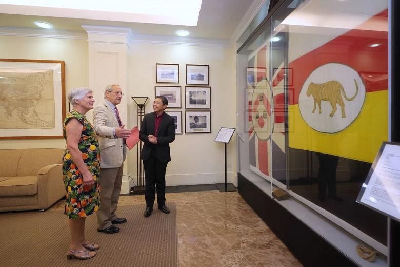 Senior Minister of State for Defence and Foreign Affairs Maliki Osman with Mr Nicholas Sherman and his wife Rosemary at the Ministry of Foreign Affairs yesterday, viewing the Union flag (left) and the flag of the Federated Malay States that were previousl