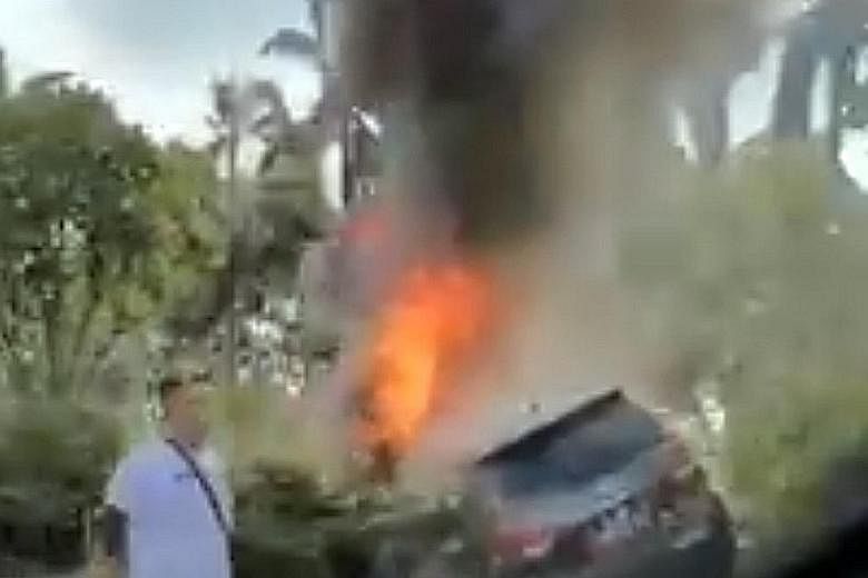 A car on fire after it crashed into the road divider on the East Coast Parkway yesterday. Video footage showed the car lodged among shrubs along the divider, with smoke billowing from it. PHOTO: PATRICK TAN/FACEBOOK The scene of the car fire incident
