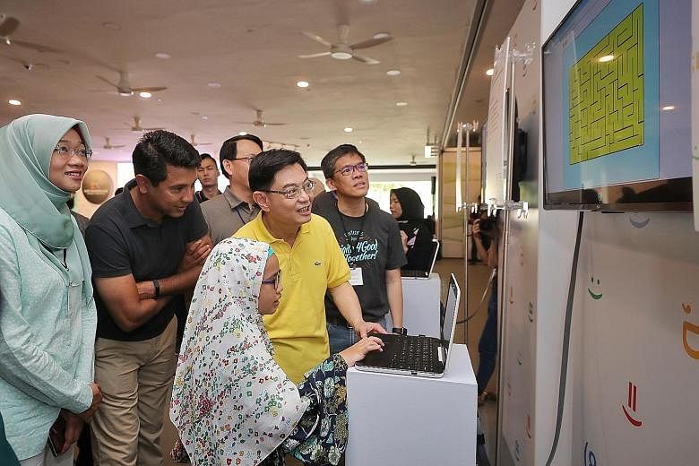 Deputy Prime Minister Heng Swee Keat and Google vice-president Caesar Sengupta looking at Sephia Rindiani Andi's colourful maze project at yesterday's graduation ceremony for students who completed the programme last year.