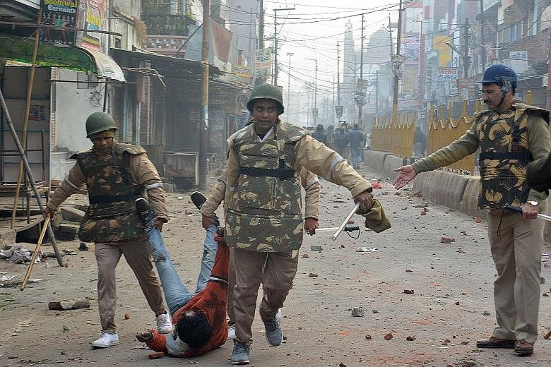 Security personnel detaining a protester during demonstrations in Meerut against India's Citizenship Amendment Act on Dec 20. Five men were shot dead in what locals call police excesses.