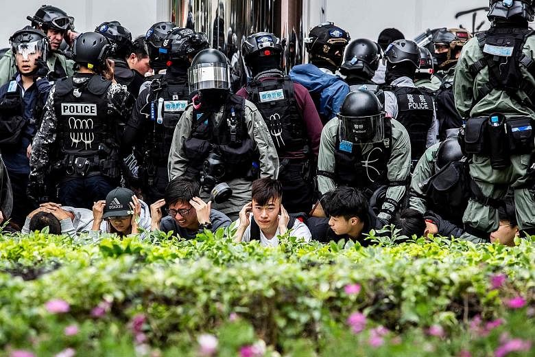 People being detained by police during a clearance operation after a demonstration against parallel trading in Sheung Shui yesterday. The trading practice frequently leaves goods in short supply in border towns.