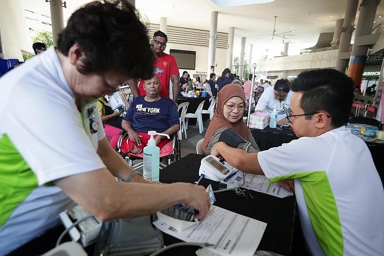 Madam Kamisha Sumadi, 68, having her blood pressure taken yesterday. The event was part of the Health Promotion Board's efforts to encourage health screening and follow-up within the Malay community.