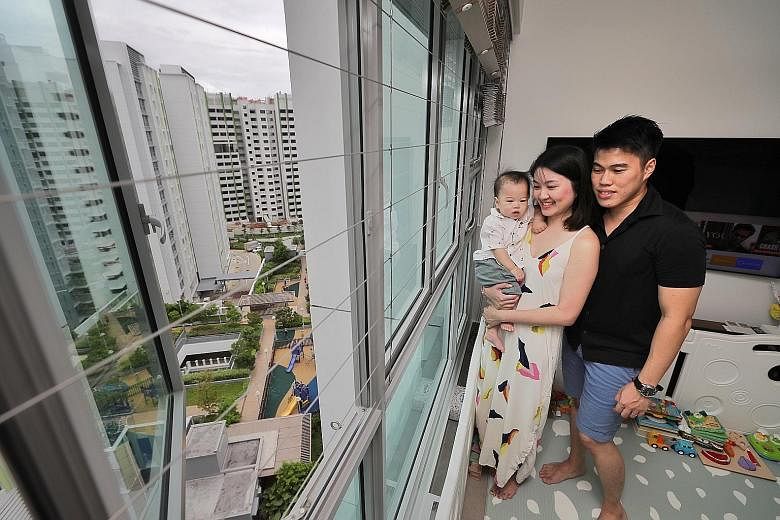 Ms Amanda Tan, 30, her husband Leonard Leong, 31, and their one-year-old son Keagan in their new flat in Bidadari's Alkaff Vista residential project. The couple received the keys to their four-room unit last July and moved in last November. ST PHOTO: