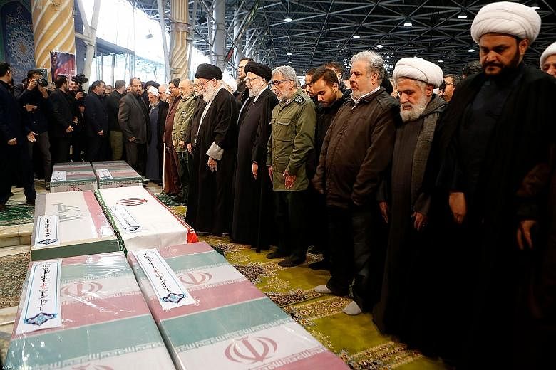 Iran's Supreme Leader, Ayatollah Ali Khamenei (seventh from right), leading a prayer as the new head of the Islamic Revolutionary Guards' Quds Force Esmail Ghaani (fifth from right) joined in the prayer session over the caskets of Major-General Qasse