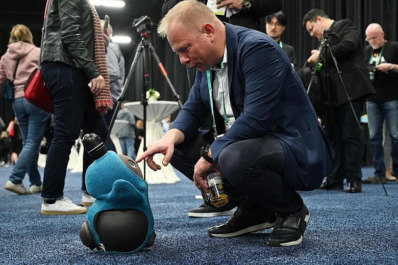 A visitor at the preview event of Consumer Electronic Show 2020 in Las Vegas on Sunday interacting with a Lovot companionship robot by Japanese firm Groove X. The robot is able to identify its owner through the use of artificial intelligence via faci