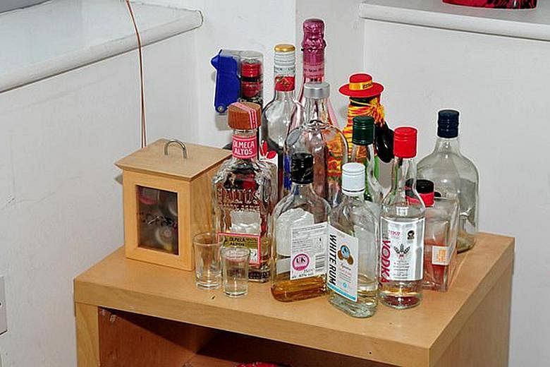 Reynhard Sinaga's apartment in Manchester, Britain, where the sexual assaults took place. Bottles of spirits (below) were found in the flat. Many of his victims recalled he gave them a drink - which he once described to a WhatsApp group as "secret po