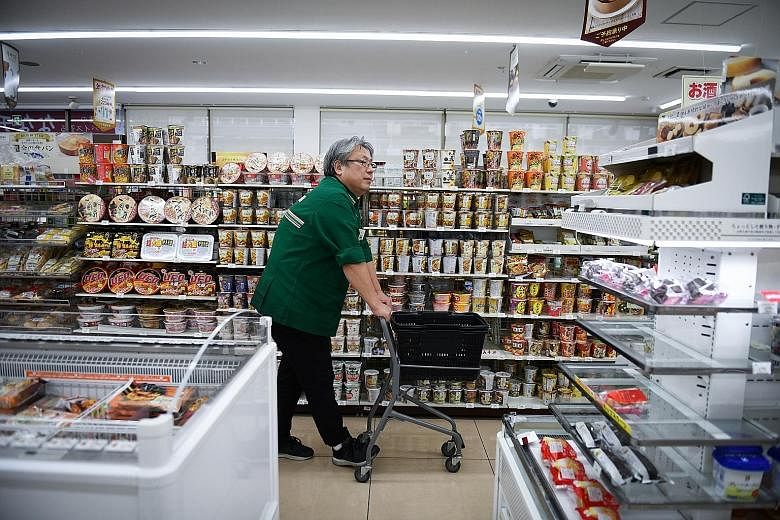 Mr Mitoshi Matsumoto in his 7-Eleven outlet near Osaka on Christmas Day. Seven & I Holdings, which controls the 7-Eleven chain, terminated his franchise last week after he decided to close his store on New Year's Day, and it has stopped supplying him