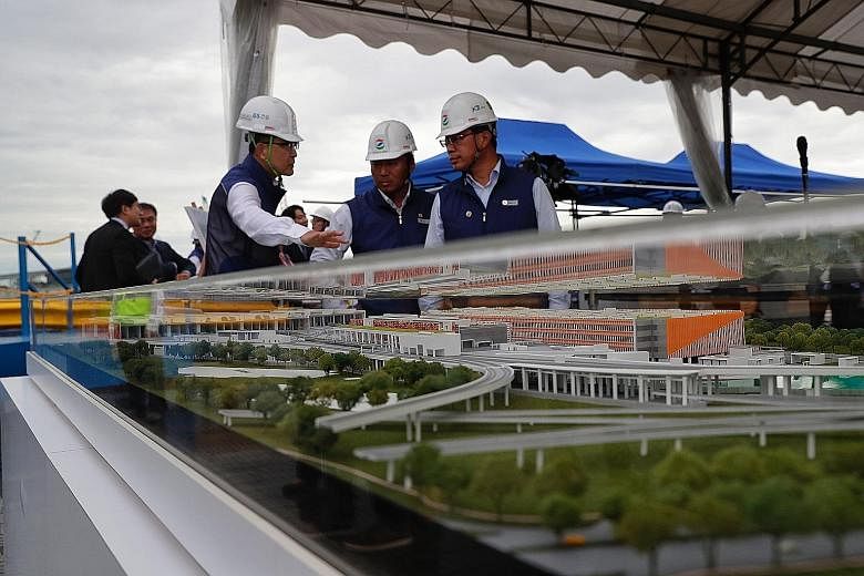 A 2018 photo of workers with a model of the Thomson-East Coast Line Integrated Depot. As construction demand is expected to remain robust, the Government is working with the industry to build better career and wage prospects.